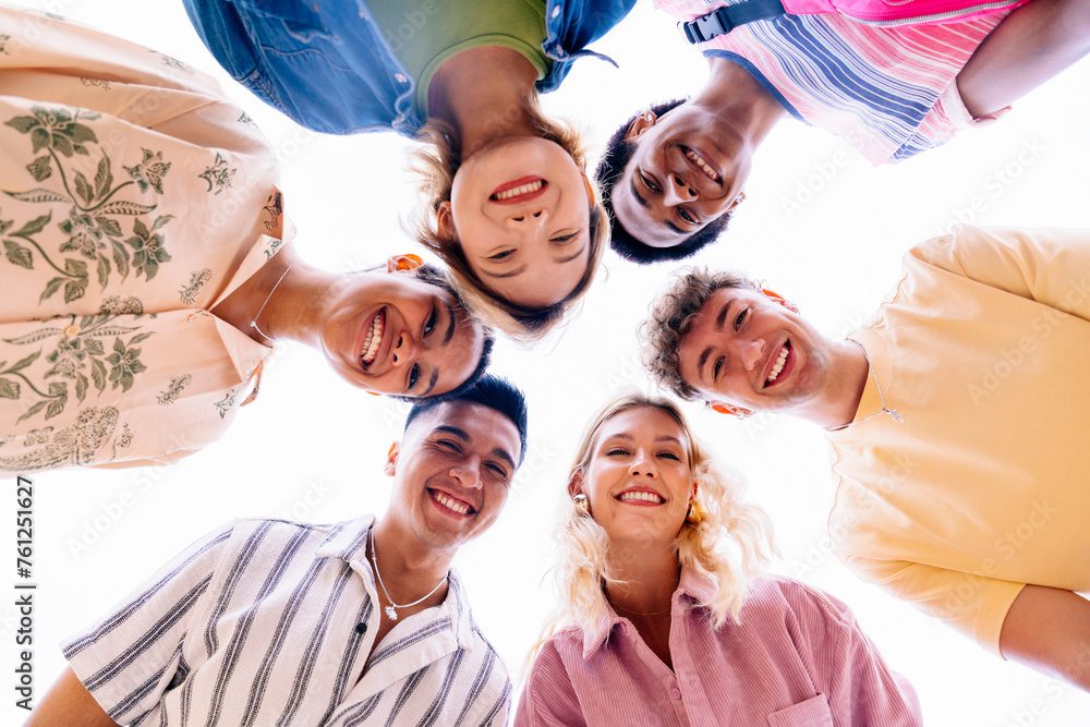 Multiethnic group of young friends with colorful clothing bonding outdoors in the city, concepts about youth and lifestyle - Barcelona, Spain