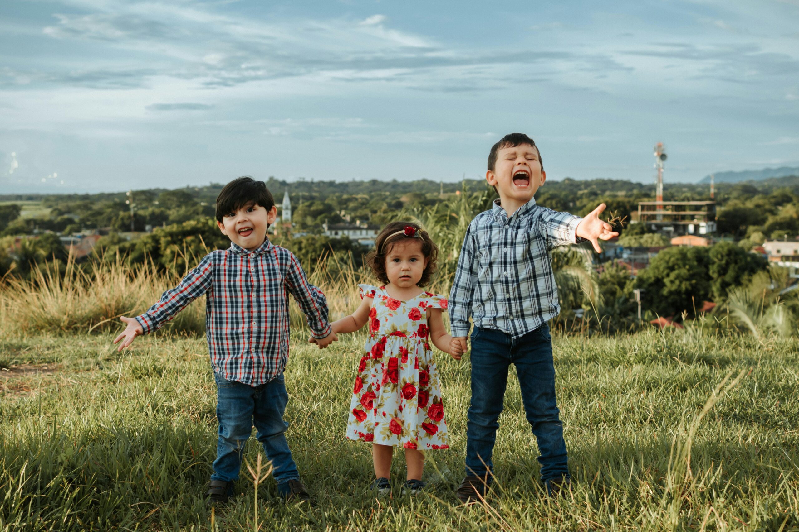 Children Standing on Grass for a Family Picture