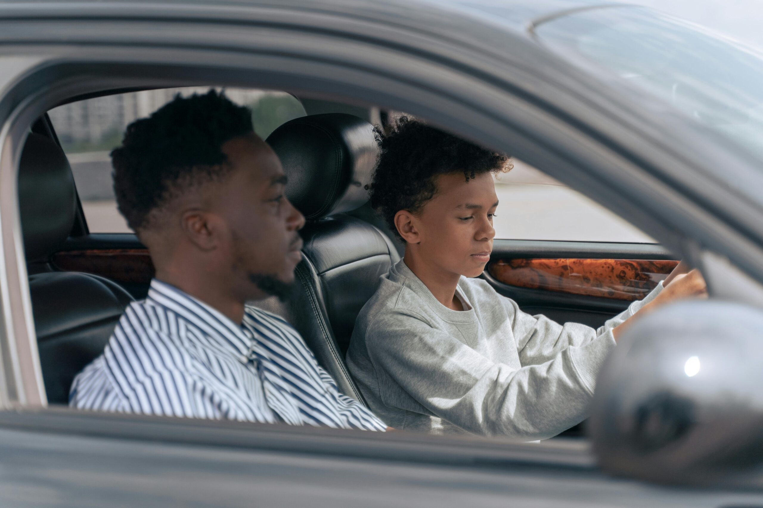 Man in White and Black Pinstripe Dress Shirt Driving Car